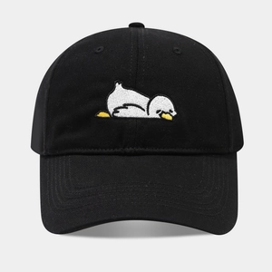 Detailed view of white cartoon duck embroidery on a black cotton baseball cap