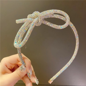 Detail shot of a handmade headband featuring colorful rhinestones and a large bow design