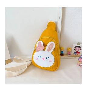 Detail of yellow canvas bunny chest bag featuring glitter ears and cute bow decoration