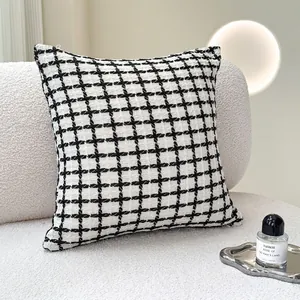 Coussin moderne en tweed à damier noir et blanc sur un canapé pour la déco