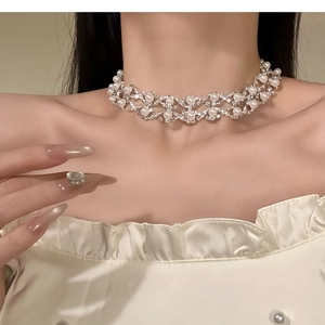 Detail of multi-layer silver rhinestone and pearl choker necklace on a model