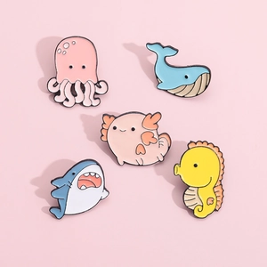 Set of 5 cartoon ocean animal enamel pins including octopus and whale on pink background