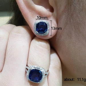 Elegantes Schmuckset mit blauen Glasohrringen und Ring, getragen von einem Modell