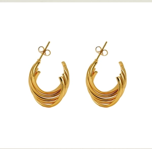 Close-up of golden multi-layered C-shaped earrings with polished 18K steel finish