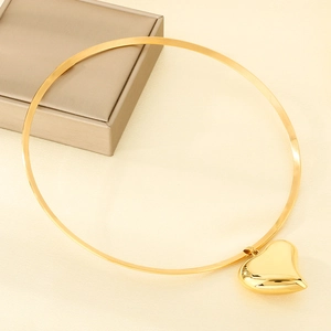 Macro detail of high-polish 18K gold-plated hollow heart pendant on a thin metal choker