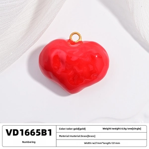 Macro shot of 27x31mm red heart pendant in brass with glossy finish and gold loop