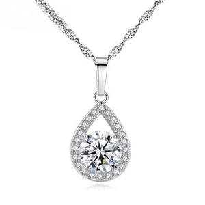 Close-up of sparkling round zircon pendant on thin necklace with detailed silver plating
