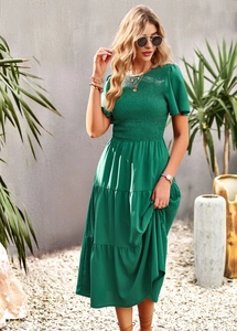 Close-up of green short-sleeve dress featuring tiered skirt and ruched chest detail