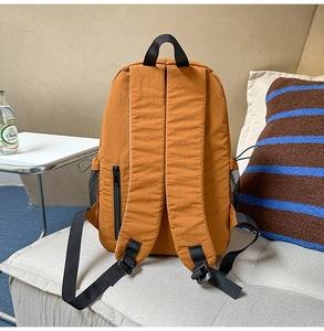 Details gepolsterter Gurte und Seitentaschen eines senfgelben Nylon-Rucksacks