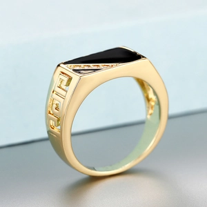 Macro shot of gold men's ring with black inlay and Greek Key pattern details