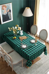 Close-up of a green and black checkered tablecloth draped on a dining table setup