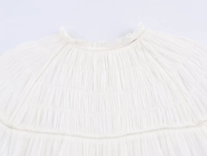 Detail of white cotton shirt featuring elegant ladder lace and shirring texture