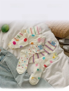 Detail of white cotton crew socks with colorful stripes, polka dots and star patterns
