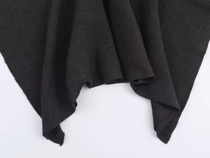 Close-up van zwart gebreide stof met fijne textuur en elegante natuurlijke drapering