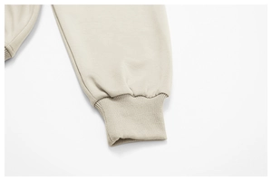 Gros plan des poignets côtelés du sweat-shirt beige montrant la maille douce