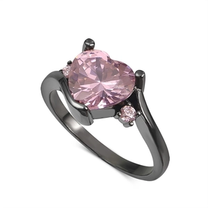 Close-up of black gold ring featuring heart-shaped pink zircon and side stone accents