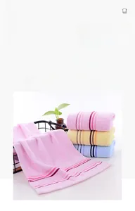 Detail of soft combed cotton towels in pink, yellow, and blue with striped texture