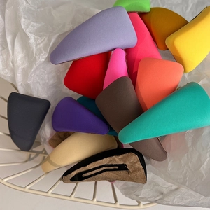 Set of colorful fabric triangle hair clips in a wire basket showing metal clip back detail