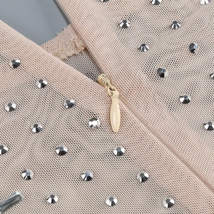 Close-up of beige bandage fabric with silver rhinestones and invisible zipper detail