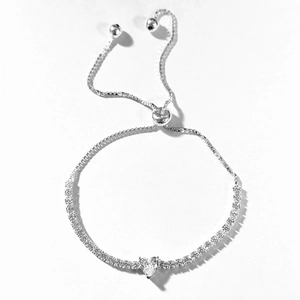 Detailed close-up of a silver heart tennis bracelet with adjustable slider clasp