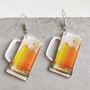 Creative clear acrylic beer glass earrings with realistic golden liquid on concrete