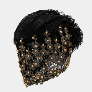 Détail du hijab en dentelle noire avec broderie dorée et perles pour un look luxueux