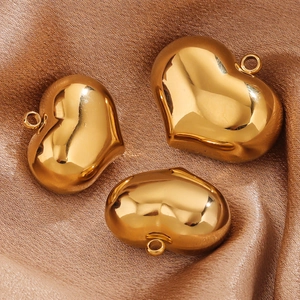Polished gold heart pendants on brown silk fabric for DIY necklace jewelry making
