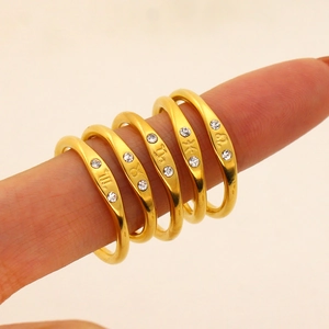 Detailed macro view of 18K gold-plated zodiac rings with rhinestones on finger