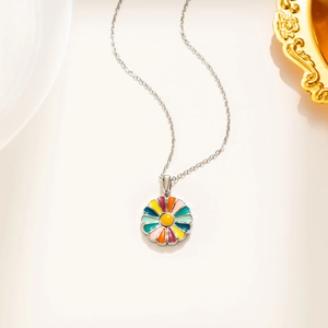 Détail du collier en acier titane argenté avec un pendentif marguerite en émail coloré