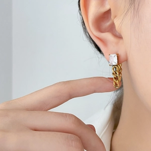 Golden earrings with rectangular zircon stone and chunky link chain shown in lifestyle view