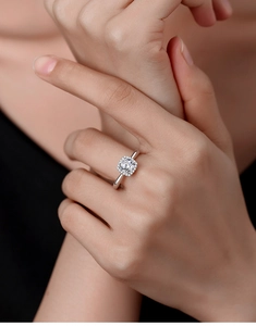 Close-up of elegant square moissanite ring with halo setting on a model hand