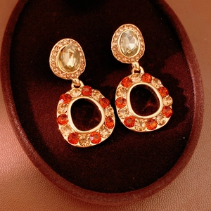 Macro shot of vintage gold earrings with rhinestones on dark velvet background