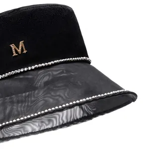 Elegant black satin fisherman hat with mesh brim, gold M logo and rhinestone detailing
