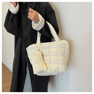 Fashionable cream quilted tote bag with matching mini coin purse shown on a model