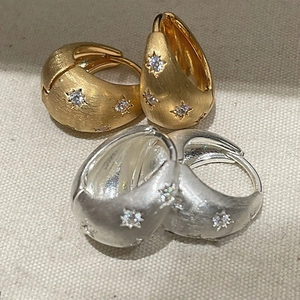 Brushed metal hoop earrings with star-shaped zircon stones in gold and silver finish