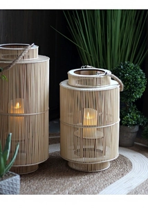 Close-up of handwoven bamboo lantern set with rustic hemp rope handles and warm candles