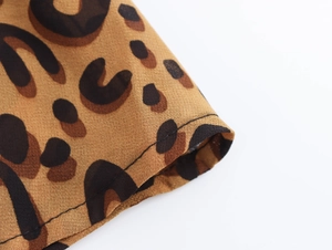 Close-up of leopard print fabric with precise stitching details on the dress hem