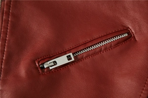 Close-up of a high-quality red leather jacket with silver zipper pocket details