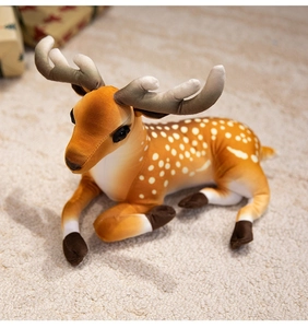 Detailed view of plush reindeer toy with white spots on soft fabric lying on a rug