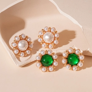 French vintage pearl and green gemstone flower earrings set in gold finish on ceramic tray