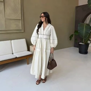 Détail de la robe longue blanche avec broderie délicate et manches bouffantes