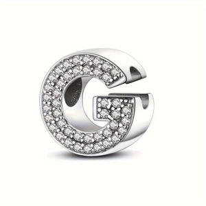 Macro detail of silver plated alphabet G charm with micro paved sparkling zircon stones