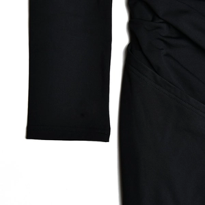 Close-up of black fabric texture and stitching details on long sleeve dress