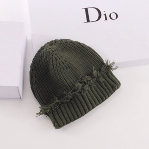 Dark green ribbed knit beanie with stylish frayed edges and a wide cuff design