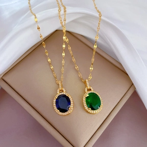 Détail de colliers goutte d'eau avec zircons bleu et vert sur chaîne dorée
