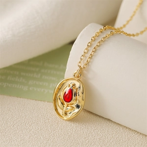 Collier vintage doré avec pendentif tulipe rouge en relief sur tissu texturé blanc