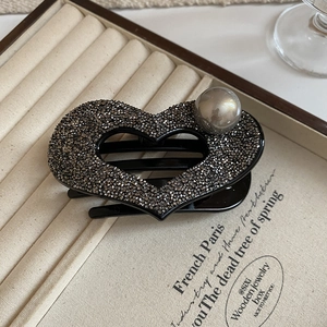Close-up of heart hair claw clip with dark grey crystals and a large pearl accent