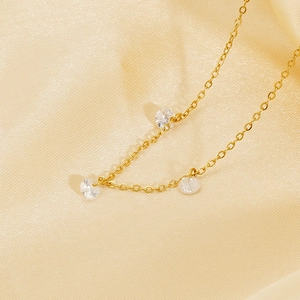Elegant gold chain necklace with three sparkling round cubic zirconia crystals on silk