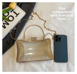 Detail of transparent clutch bag with gold rhinestones and metallic handle for evening