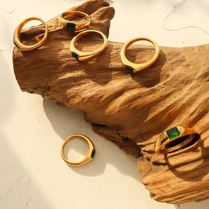French style 18K gold plated stainless steel ring with green zircon on natural wood